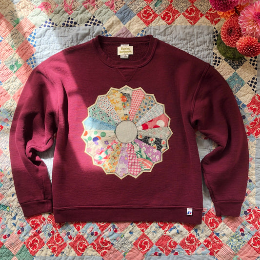 Burgundy crewneck sweatshirt with Dresden Plate vintage quilt patch sewn to front by Flower Supernova.