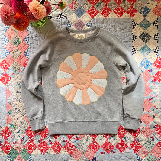 Gray crewneck sweatshirt with Dresden Plate vintage quilt patch sewn to front by Flower Supernova.