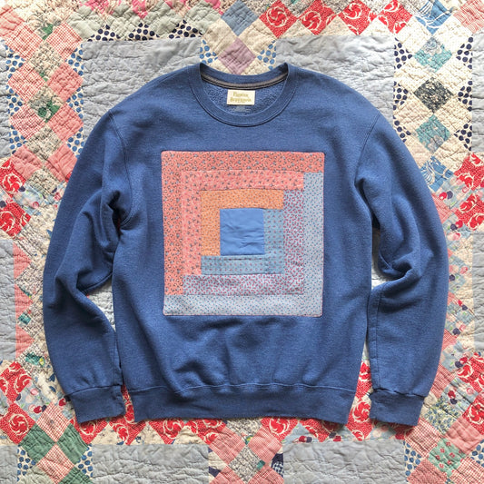 Blue crewneck sweatshirt with vintage Log Cabin quilt patch sewn to front by Flower Supernova.