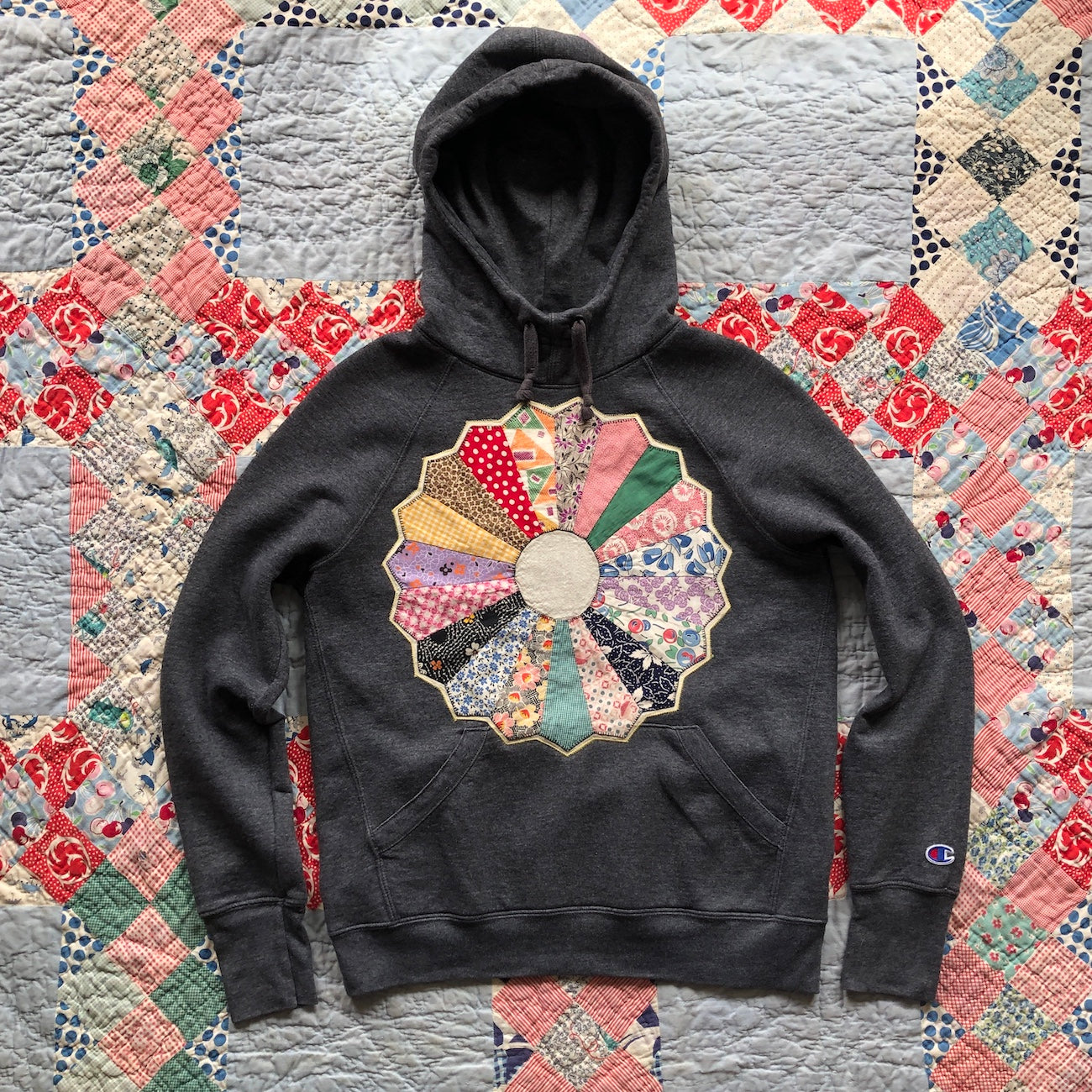 Women's dark gray hoodie with Dresden Plate vintage quilt patch sewn to front by Flower Supernova.