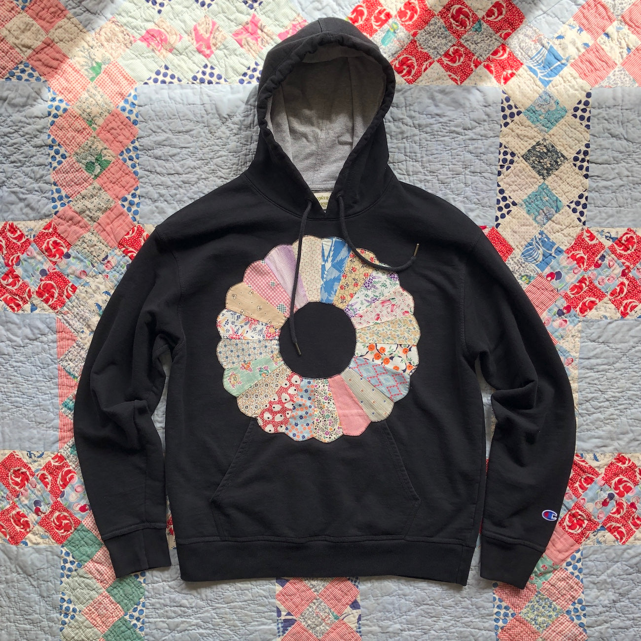 Black Men's hoodie with Dresden Plate vintage quilt patch sewn to front by Flower Supernova.